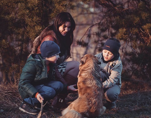 Two boys with their mom and their dog